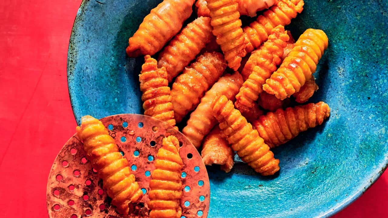 Ridged golden fried pastry pieces sit on a blue bowl.