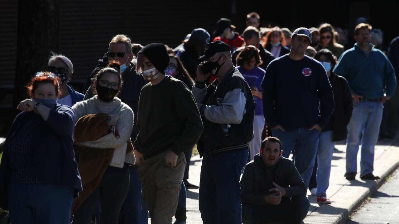 People wait in line to cast their votes at Northern High School, on 3 November, 2020 in Owings, Maryland.