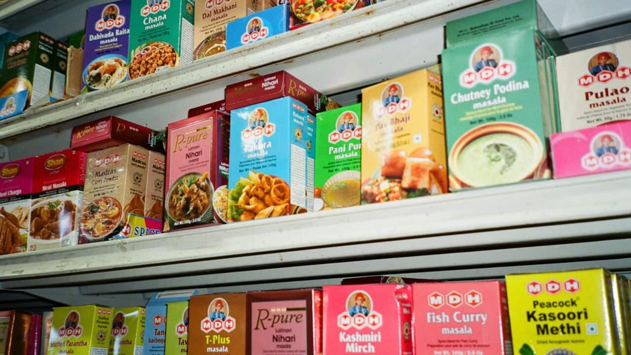 Prepared food items are arranged on a shelf at an Indian grocery store