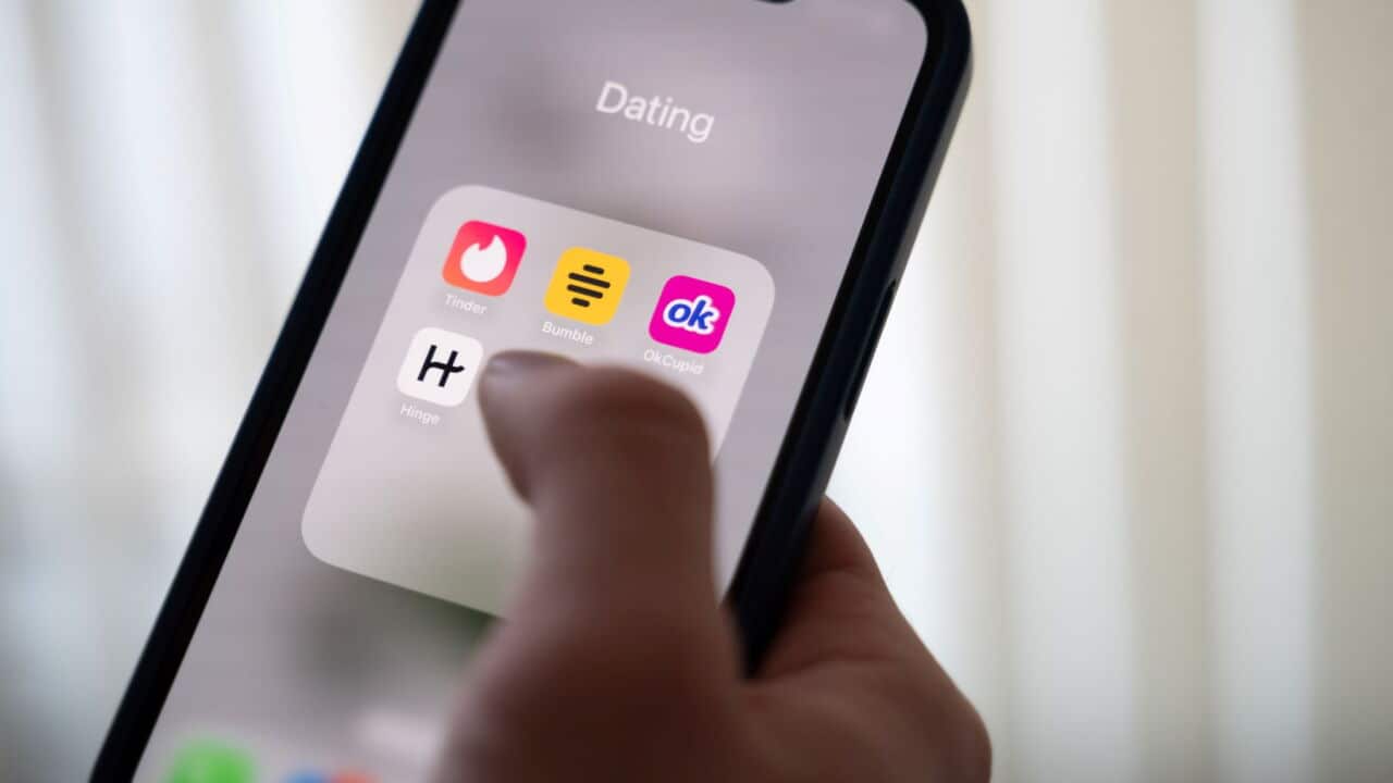 A woman holds a smartphone displaying dating apps (Alicia Windzio-dpa).jpg