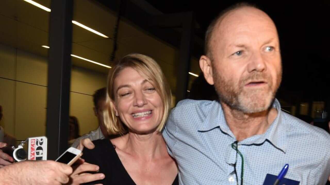 Tara Brown (L) and Stephen Rice arrive at Sydney International Airport