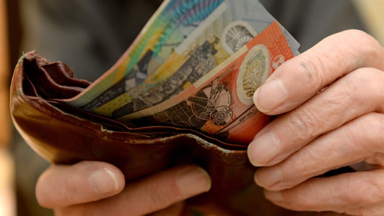 A person takes money out of a wallet