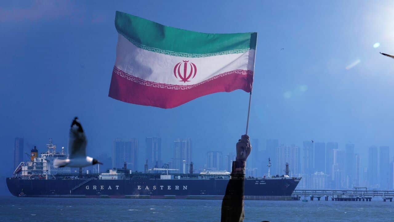 An Iranian flag and a vessel on the Strait of Hormuz