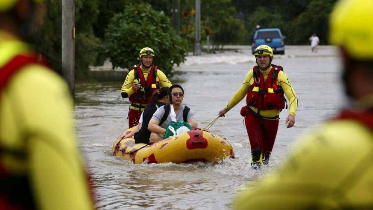 Queensland Fire and Emergency Services crew members use an inflatable boat to pull residents through floodwaters in Hermit Park Townsville, Sunday, February 3, 2019. (AAP Image/Andrew Rankin) NO ARCHIVING