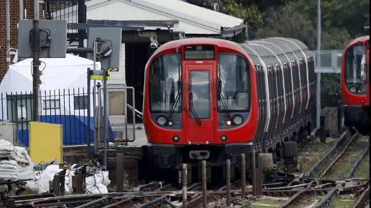 A police forensic tent next to a train at Parsons Green subway station