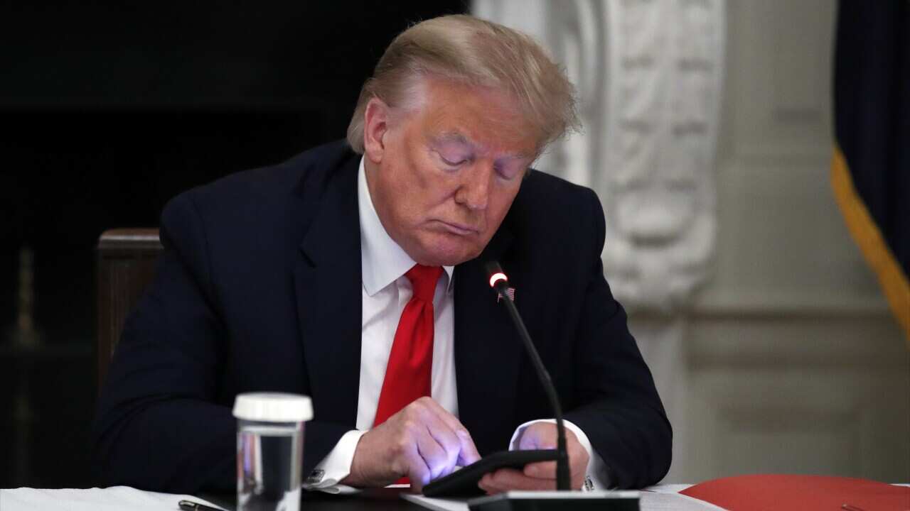 A file photo of President Donald Trump looking at his phone.