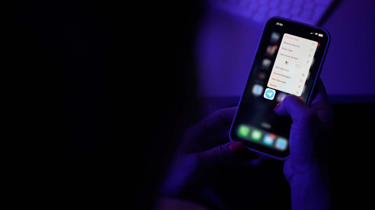 A person using a smartphone is about to open the Telegram messaging app.