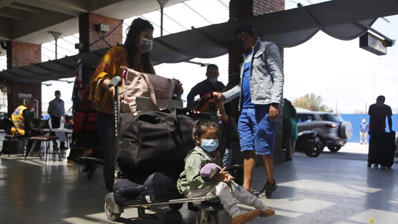 Stranded Australian citizens stand in a queue to board a flight back to their country in Kathmandu, Nepal, Wednesday, May 6, 2020.