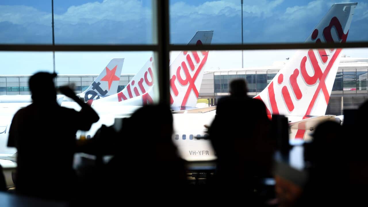 Silhuetas de pessoas à espera do seu avião em ambiente de aeroporto