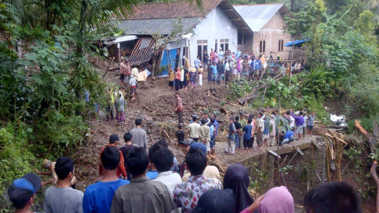 Residents gather in front of a house which was damaged by a landslide in Susukan village, Banjarnegara, Indonesia, 19 June 2016.