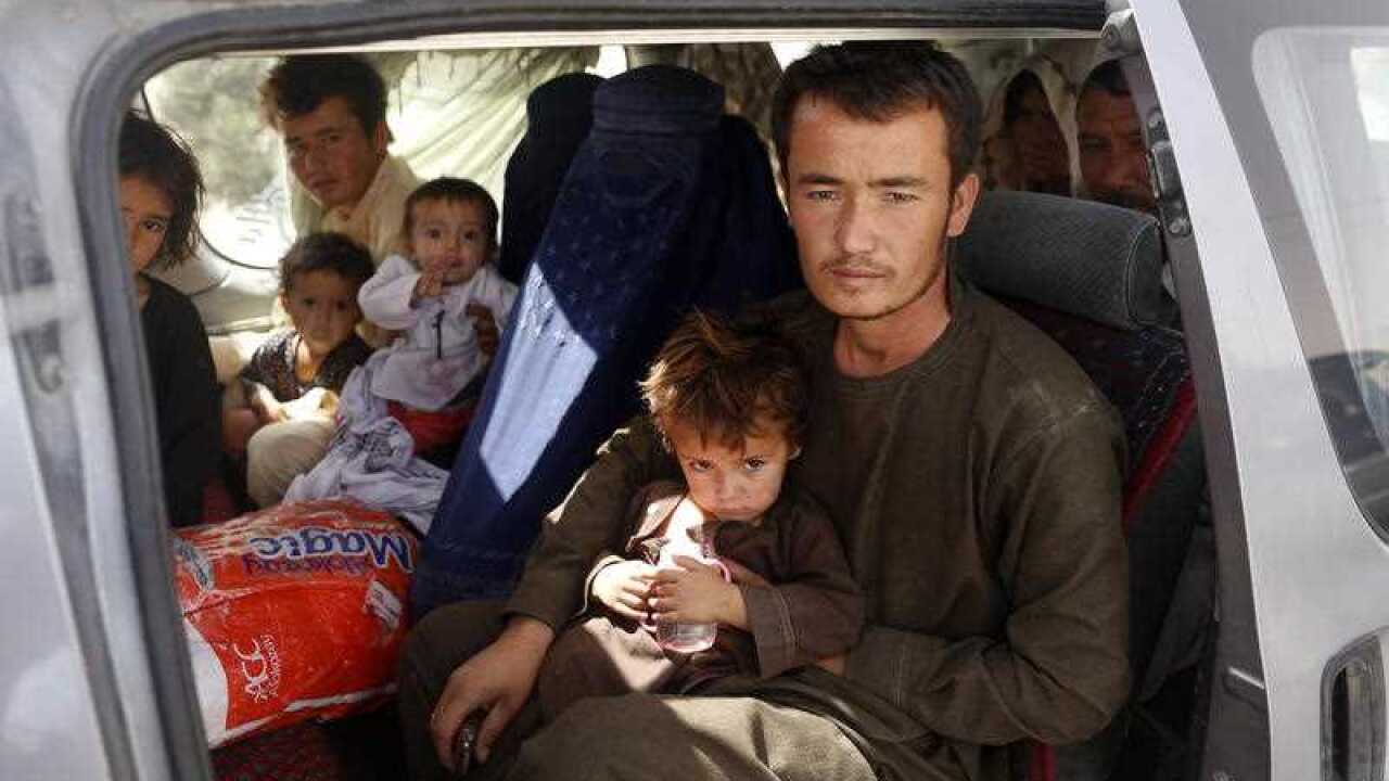 An Afghan family, who have escaped from the volatile city of Ghazni province, poses for a photograph in the entrance gate of Kabul, Afghanistan, 13 August 2018.