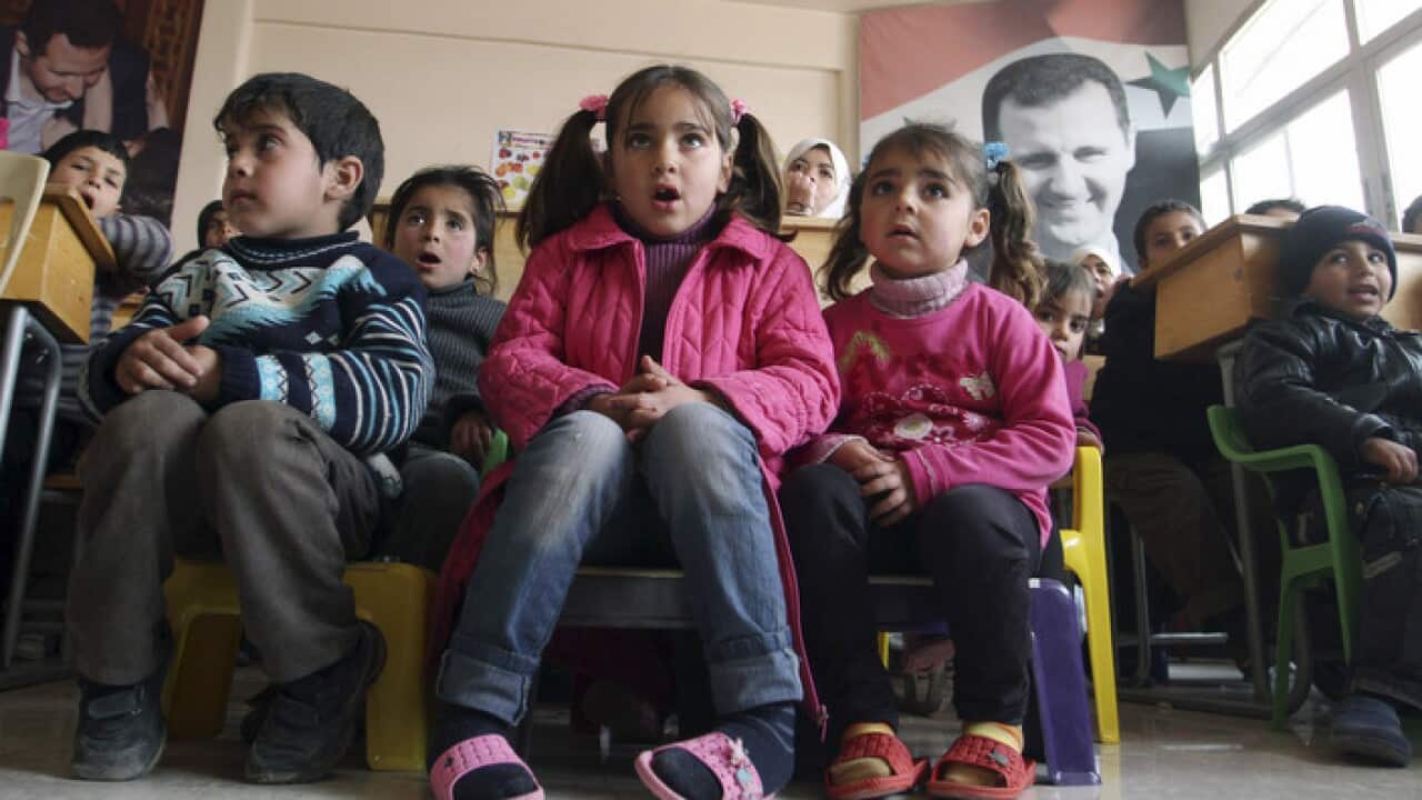 Displaced Syrian children gather in a classroom in a school that has been turned into a temporary shelter in the Qudsaya neighborhood on the outskirts of Damascus