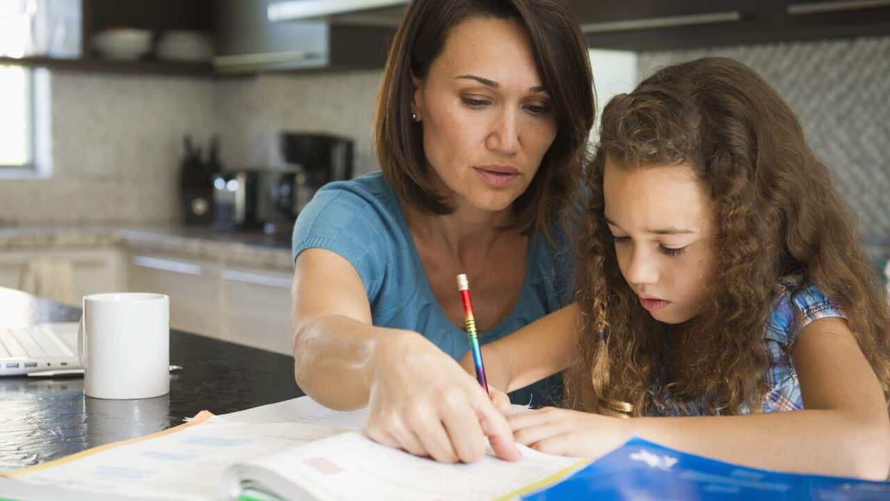 Woman helping daughter with her studies (Getty Images).