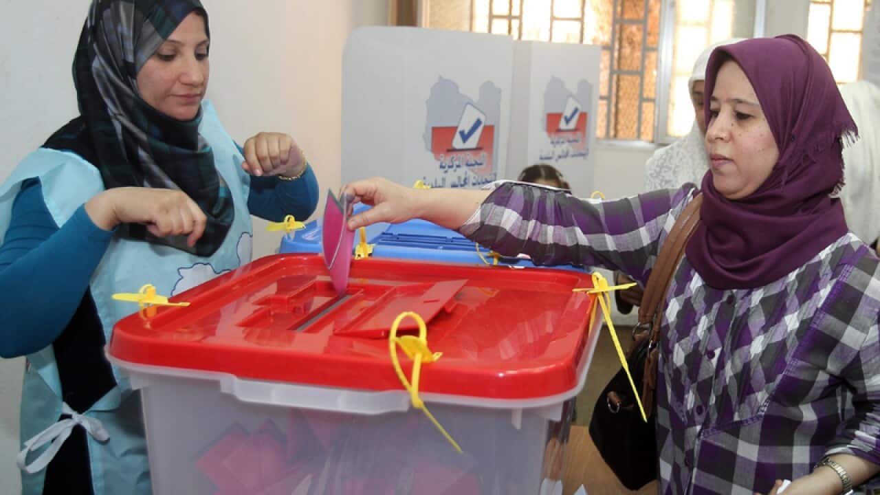 A Libyan woman casts her vote during municipal elections