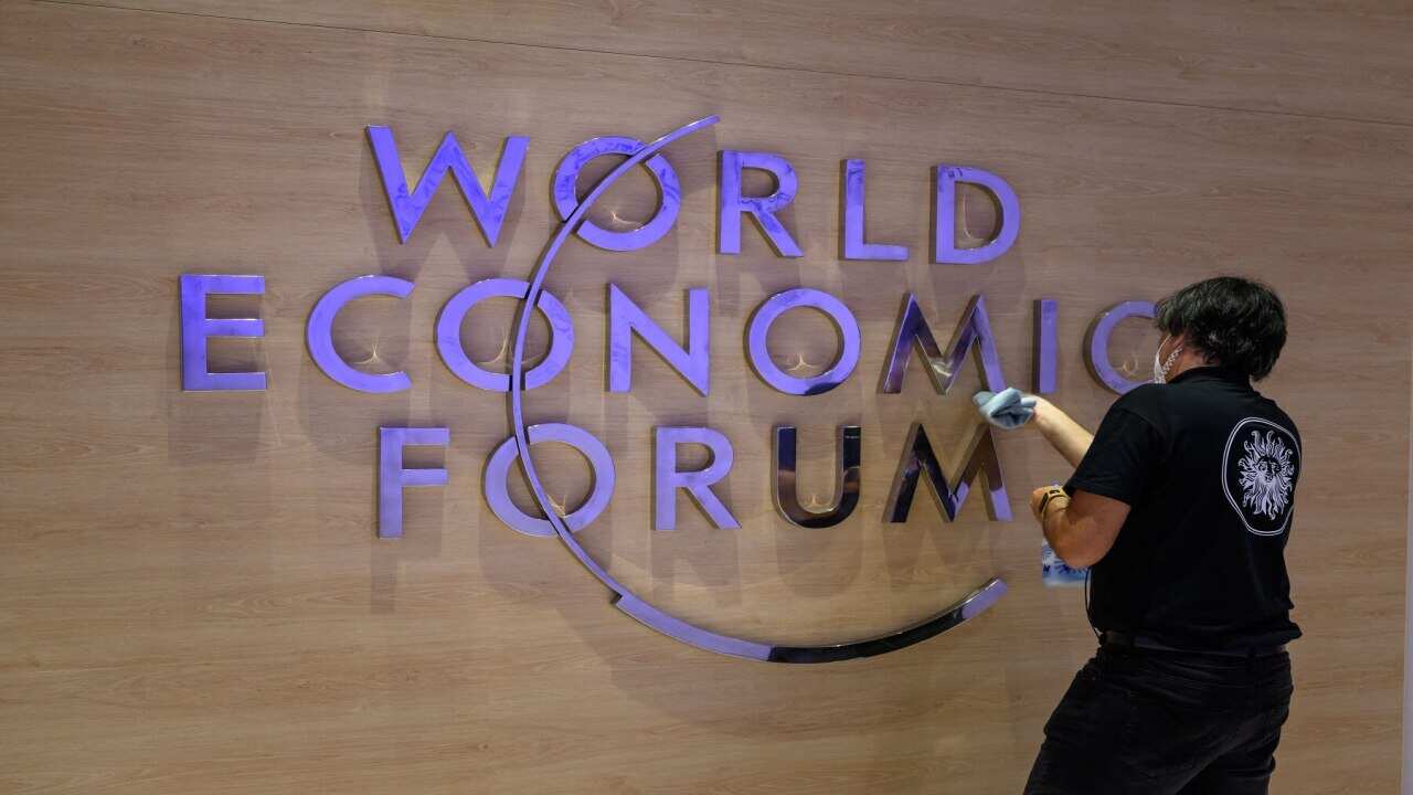 A worker cleans a sign of the logo of the World Economic Forum (WEF) inside the Congress centre ahead of the WEF annual meeting in Davos on May 22, 2022. (Photo by Fabrice COFFRINI / AFP) (Photo by FABRICE COFFRINI/AFP via Getty Images)