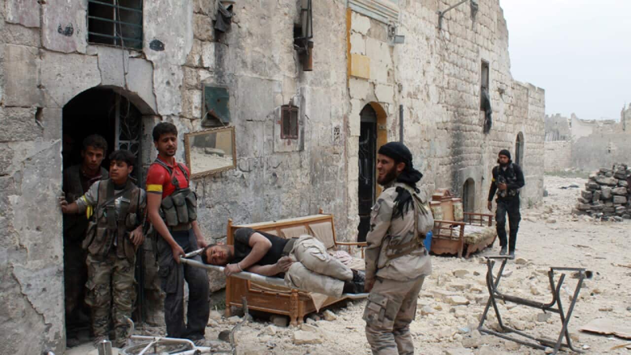 Syrian opposition fighters carry an injured comrade, Aleppo