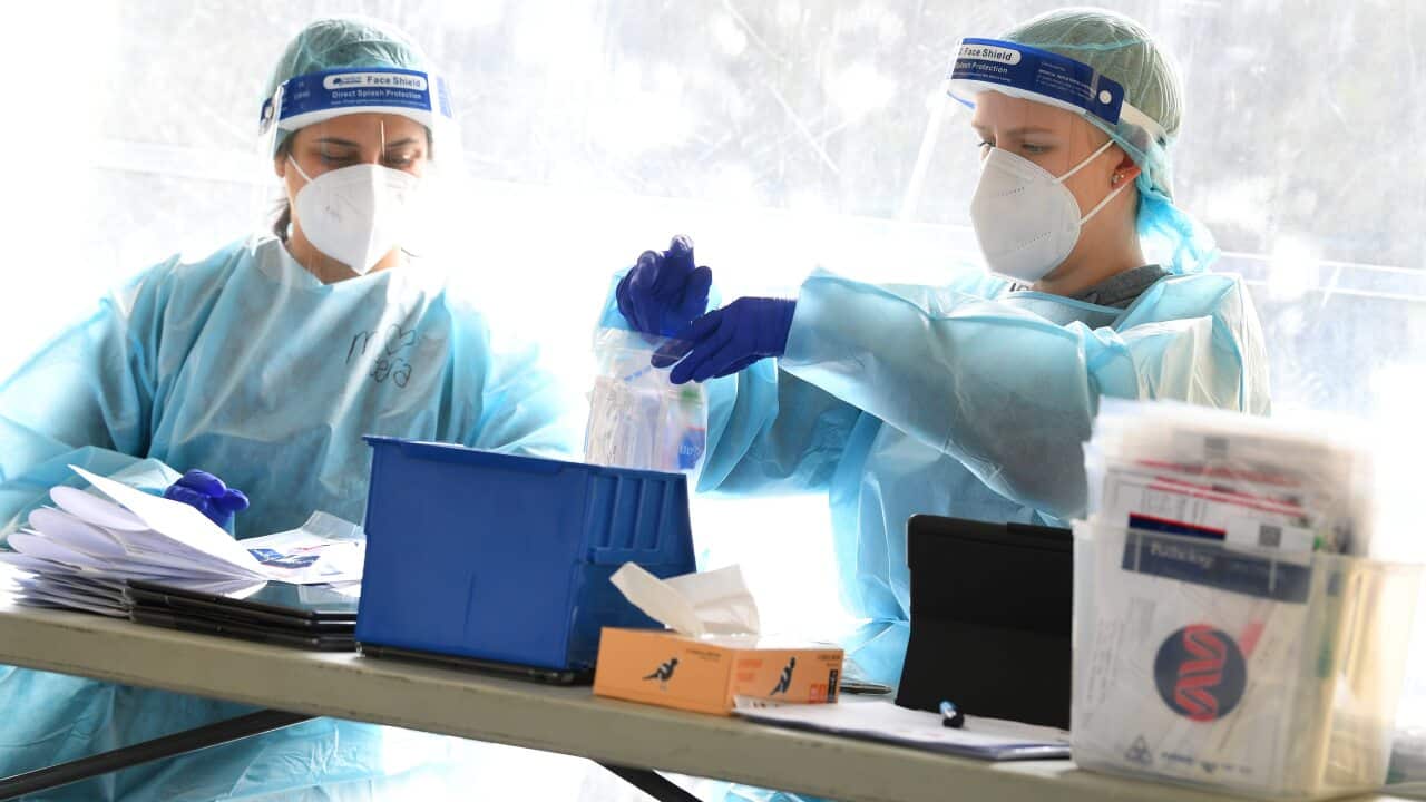 Healthcare workers are seen at a drive through pop up coronavirus testing facility in Clyde, Melbourne.