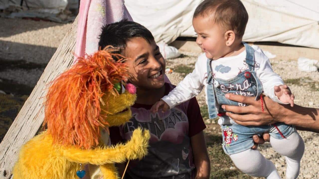 Muppet meets young children in Lebanese Refugee Camp