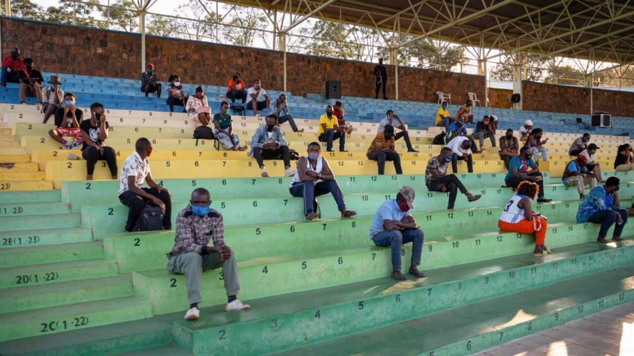 People who break coronavirus restrictions, are forced to sit and listen to speeches about its prevention in Rwanda.