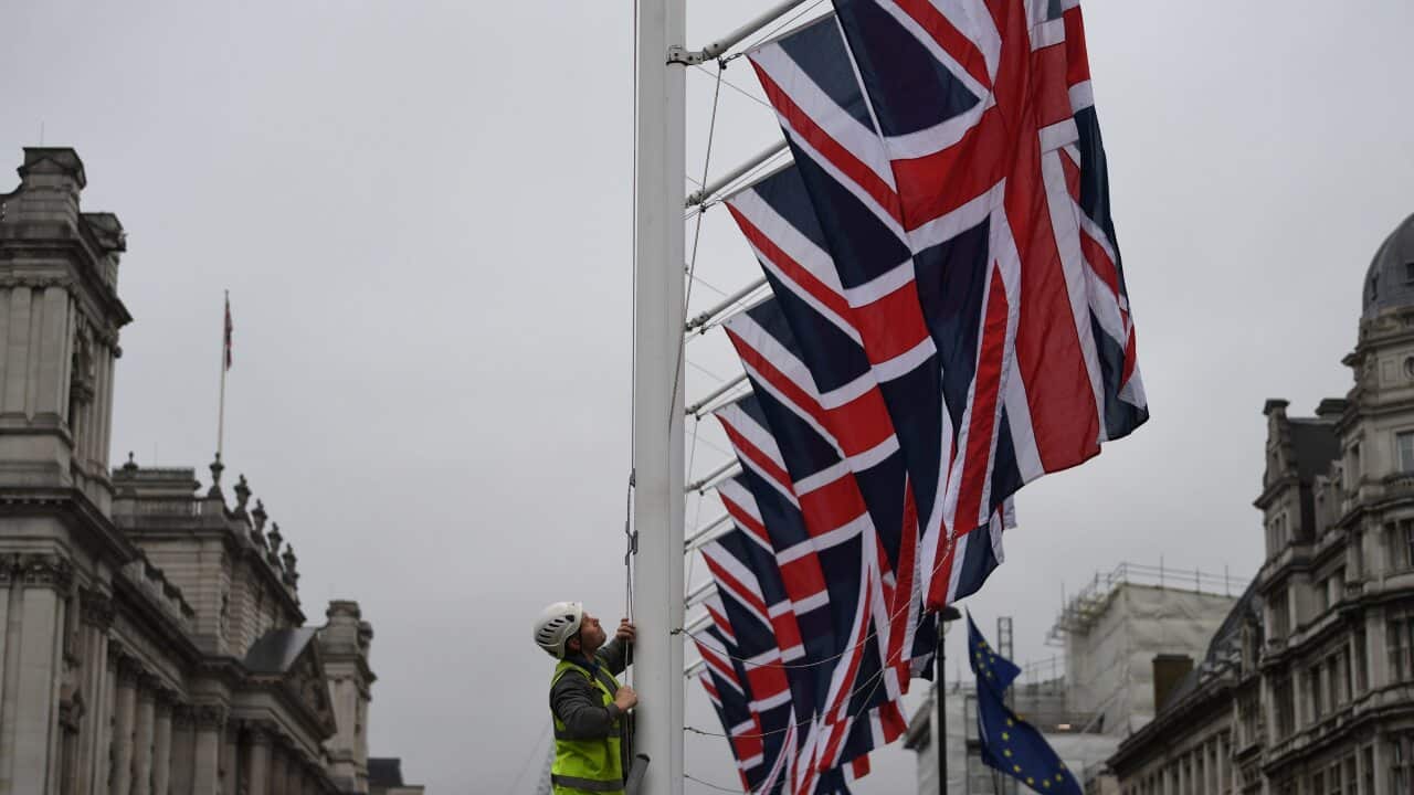 epaselect epa08178581 A man raises Union Flags on Parliament Square in London, Britain, 30 January 2020. After a process that lasted over three years, Britain's withdrawal from the EU is set for midnight CET on 31 January 2020. EPA/NEIL HALL