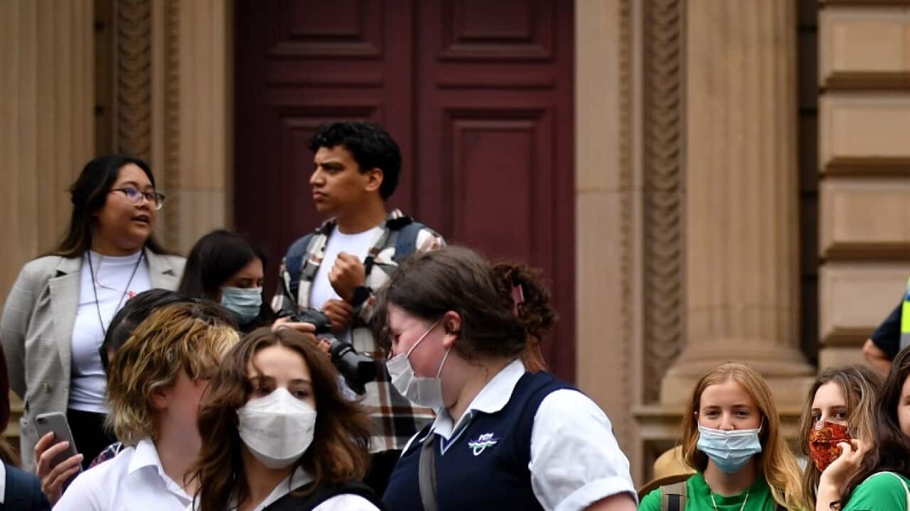 School students hold placards during a Climate School Strike protest at Treasury Gardens in Melbourne, Friday, March 25, 2022. (AAP Image/Joel Carrett) NO ARCHIVING