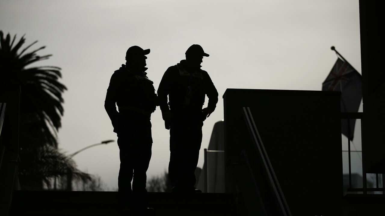 Protective service officers are seen prior to a press conference in Melbourne.