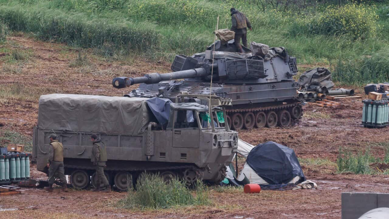 An army soldier stands on a self-propelled Howitzer artillery gun
