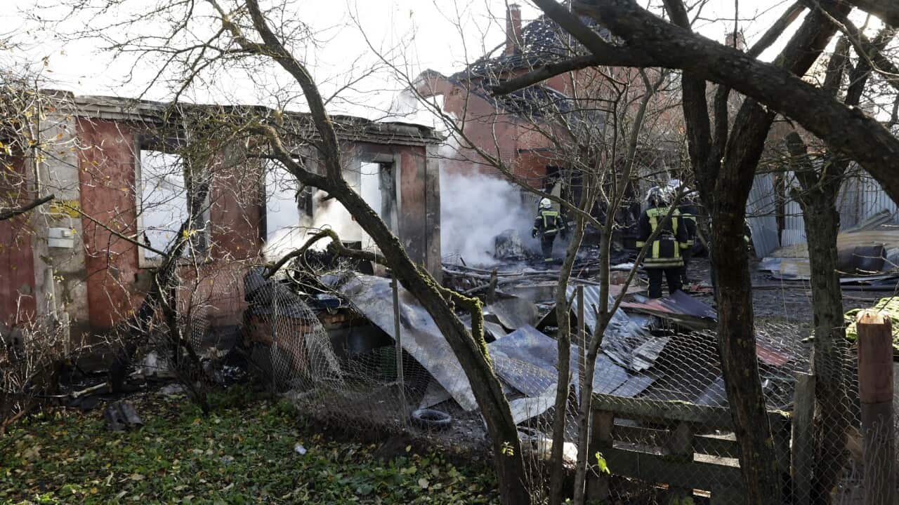 Rescuers work to extinguish a fire in a house following a drone attack in the village of Stanovoye, Moscow.