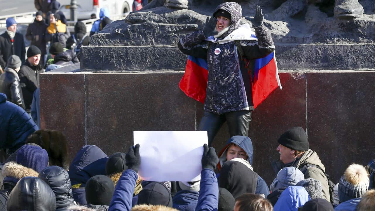 A demonstrator covered by a Russian national flag shouts slogans during a rally in Vladivostok, Russia.