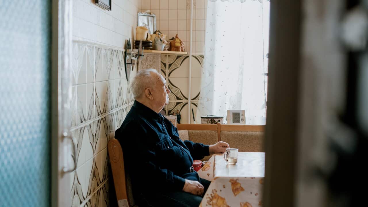 Senior Man Sitting in a Cozy Kitchen, Reflecting by the Daylight