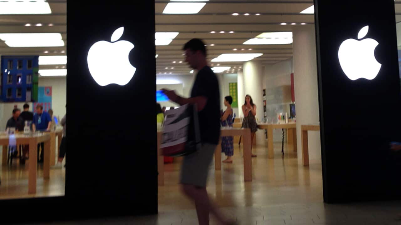 A shopper walks by an Apple store in Peabody, Mass.