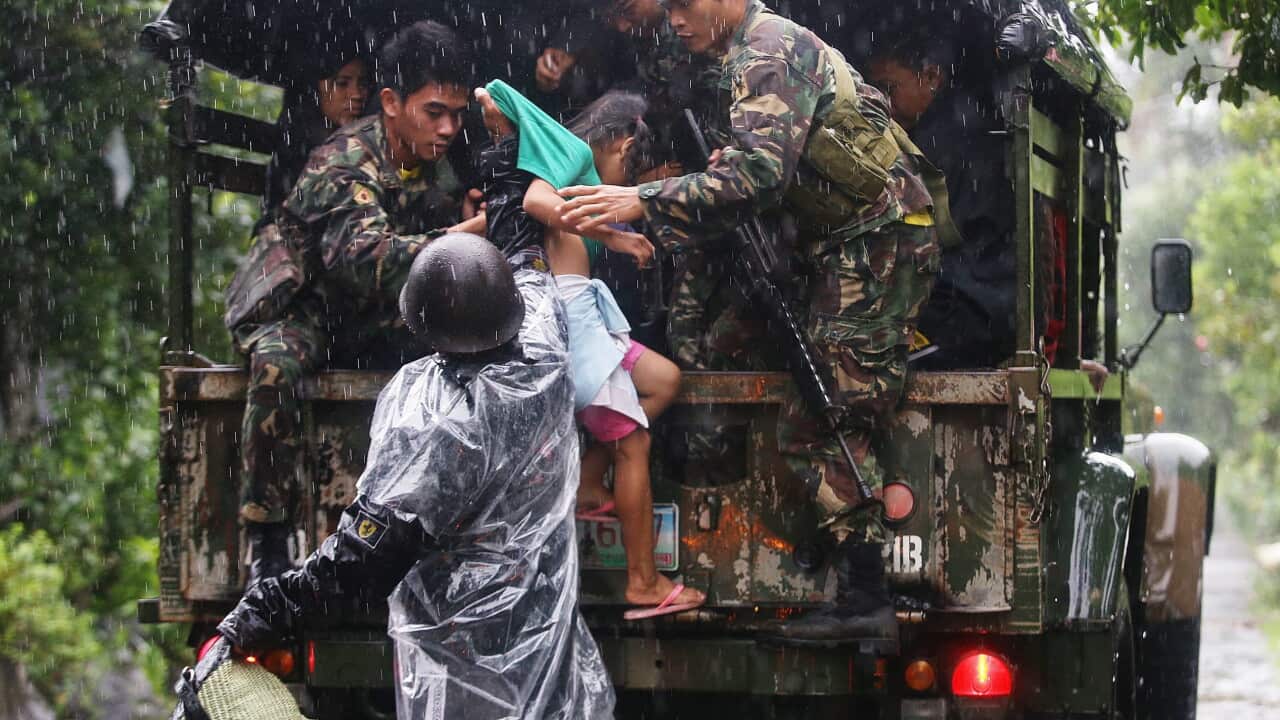 Filipino soldiers assist a child to board a truck bound for evacuation centers in Legazpi City, Albay province, southern Manila, Philippines.