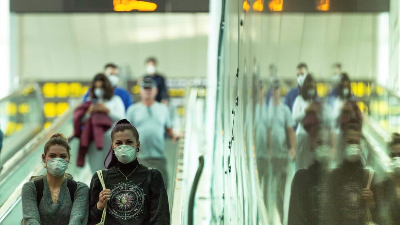 Travelers wear protective masks at the airport in Barcelona, Spain.
