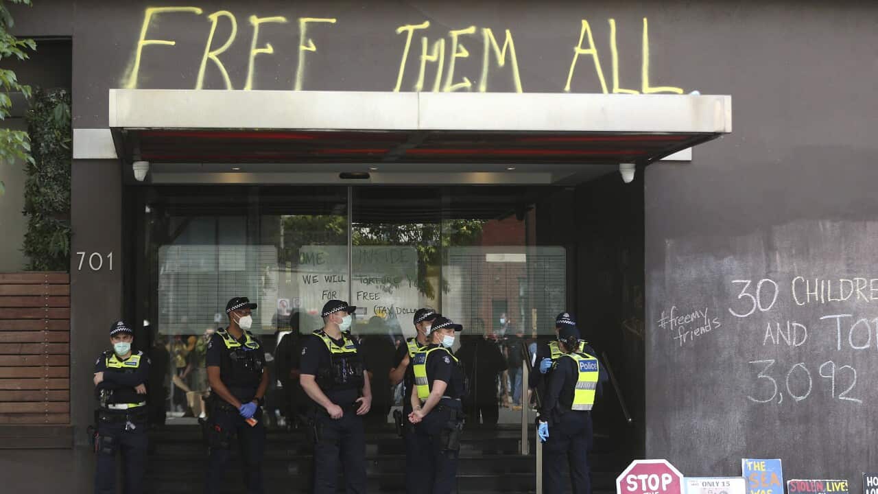Police stand guard outside the refugee detention hotel, the Park Hotel in Melbourne, Australia.