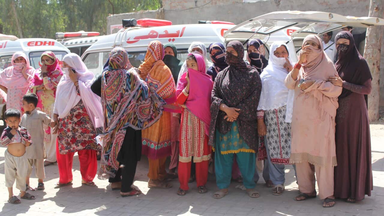 Relatives wait to receive bodies of the victims who were killed by a faith healer in Sargodha, Pakistan.