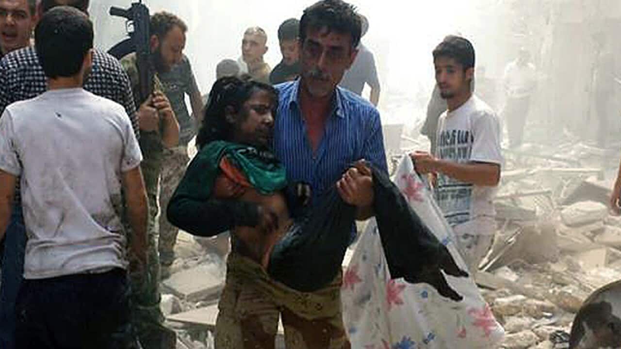 A Syrian man carrying a wounded girl
