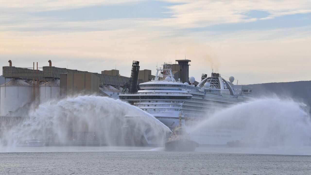 A tugboat sprays water as the Ruby Princess cruise ship prepares to depart Port Kembla in Wollongong, New South Wales