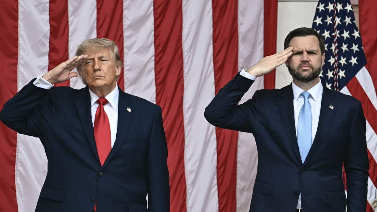 Donald Trump and JD vance salute in front of an American flag.