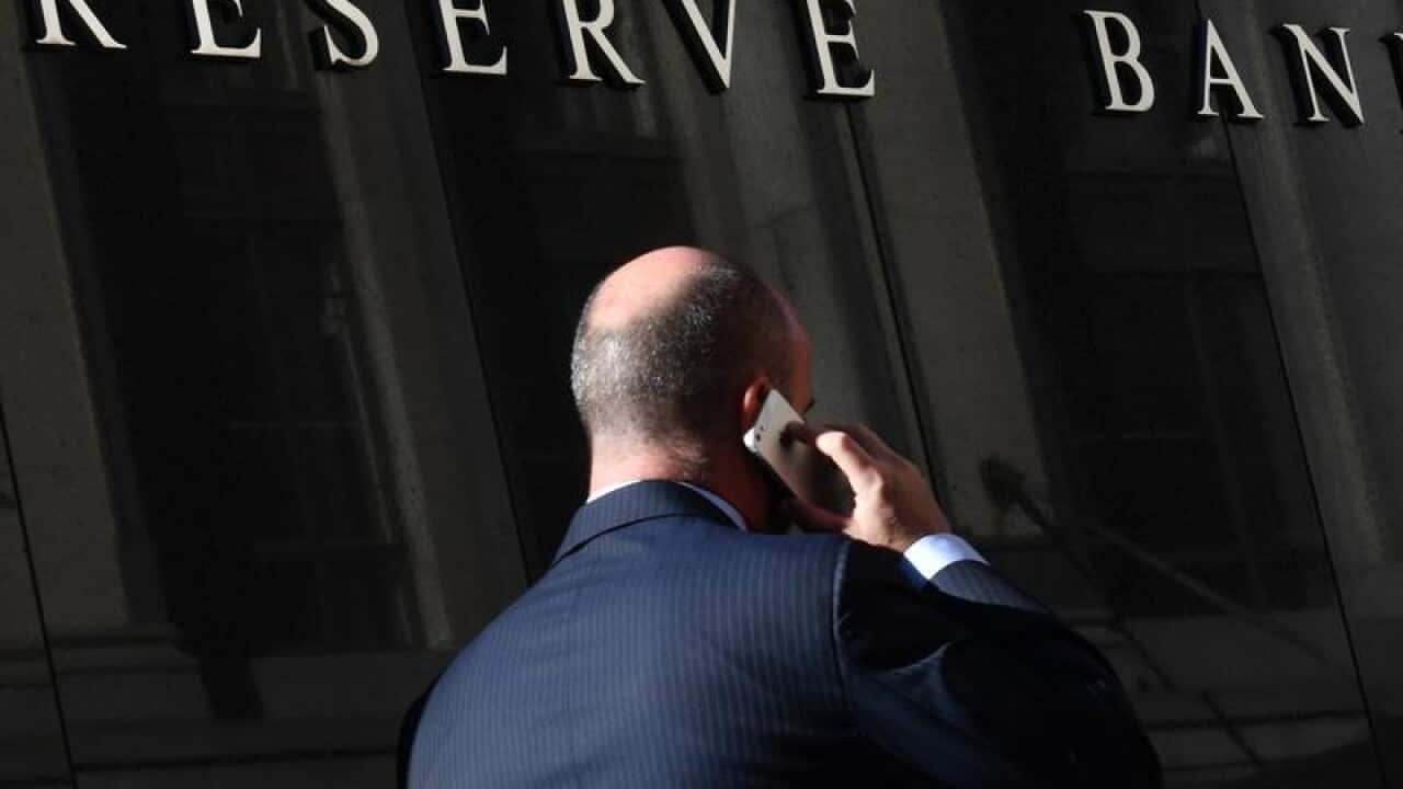 A pedestrian walks past the Reserve Bank of Australia