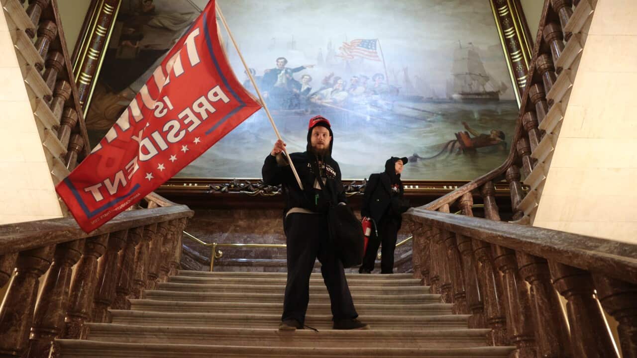 A protester holds a Trump flag inside the US Capitol Building near the Senate Chamber.