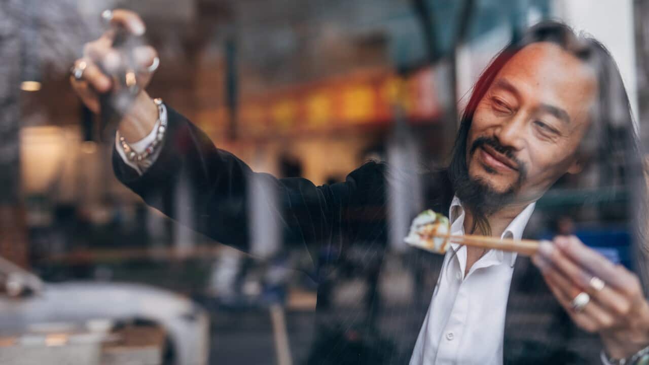 Mature man taking a selfie while eating sushi