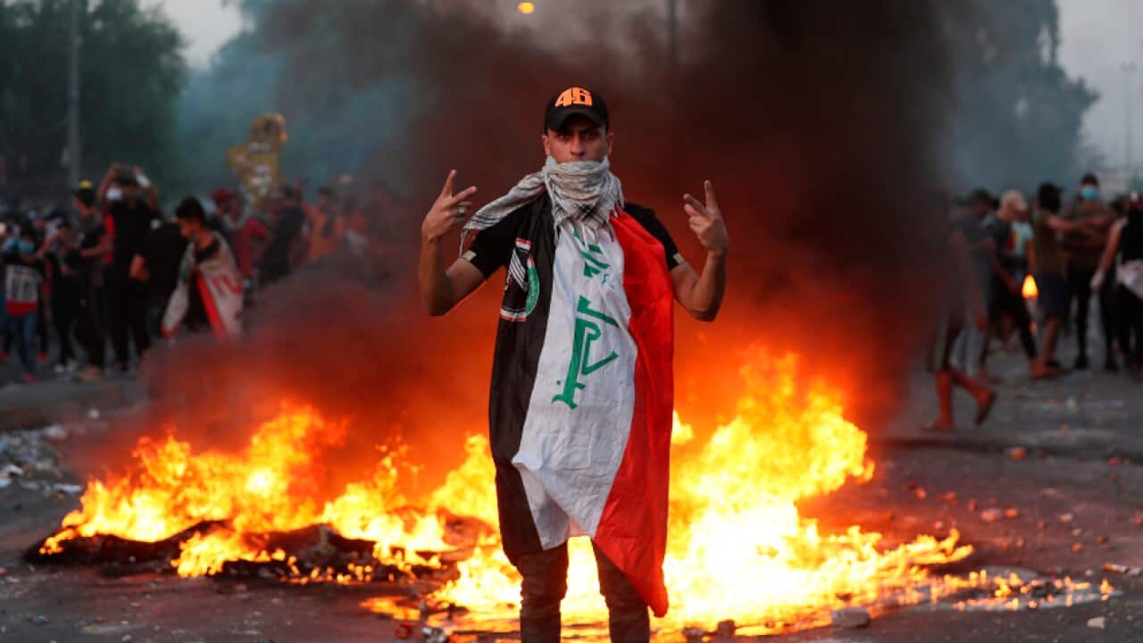 An anti-government protester flashes the victory sign during a demonstration, in Baghdad, Iraq, Thursday, Oct. 3, 2019.