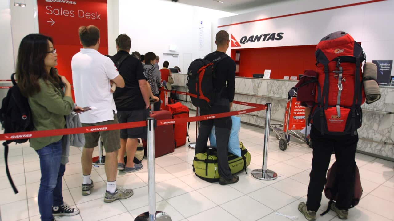 Passengers wait in a queue at Sydney Airport