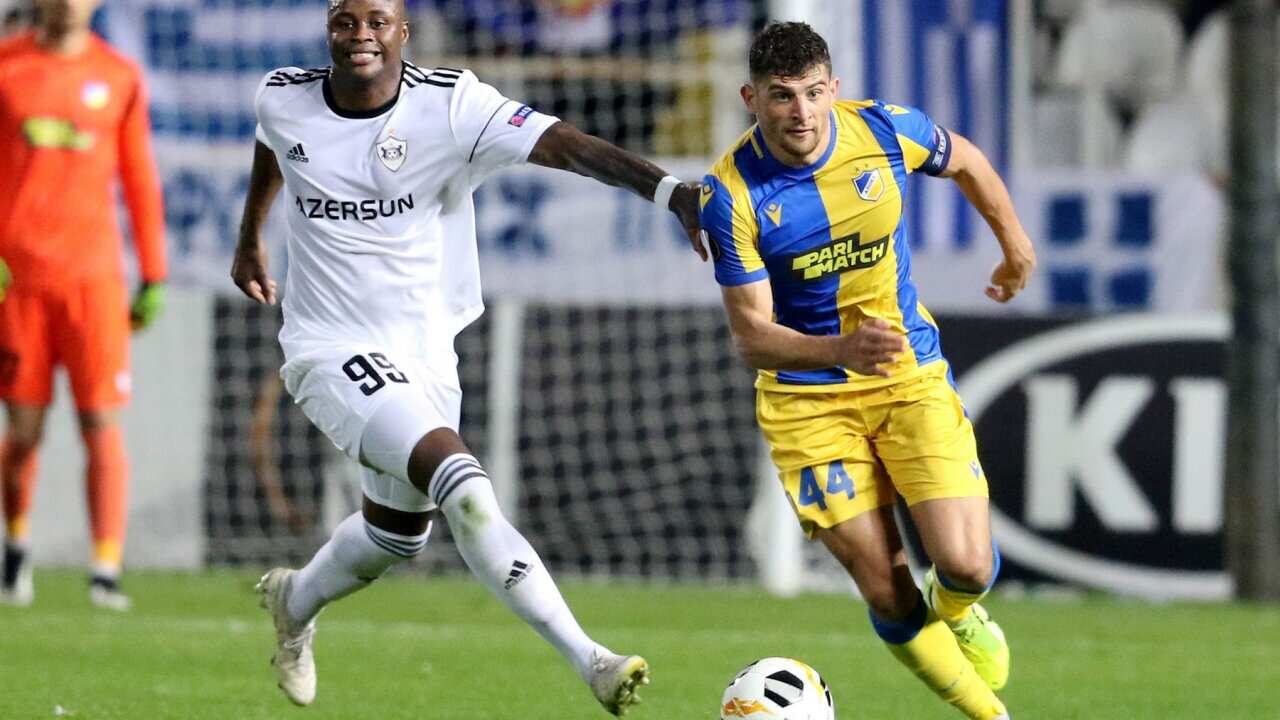 POEL's Nicholas Ioannou (R) vies for the ball with GARABAG's Magaye Gueye during the UEFA Europa league Group A football match between APOEL FC and QARABAG FK at the GSP stadium in the capital Nicosia on November 7, 2019