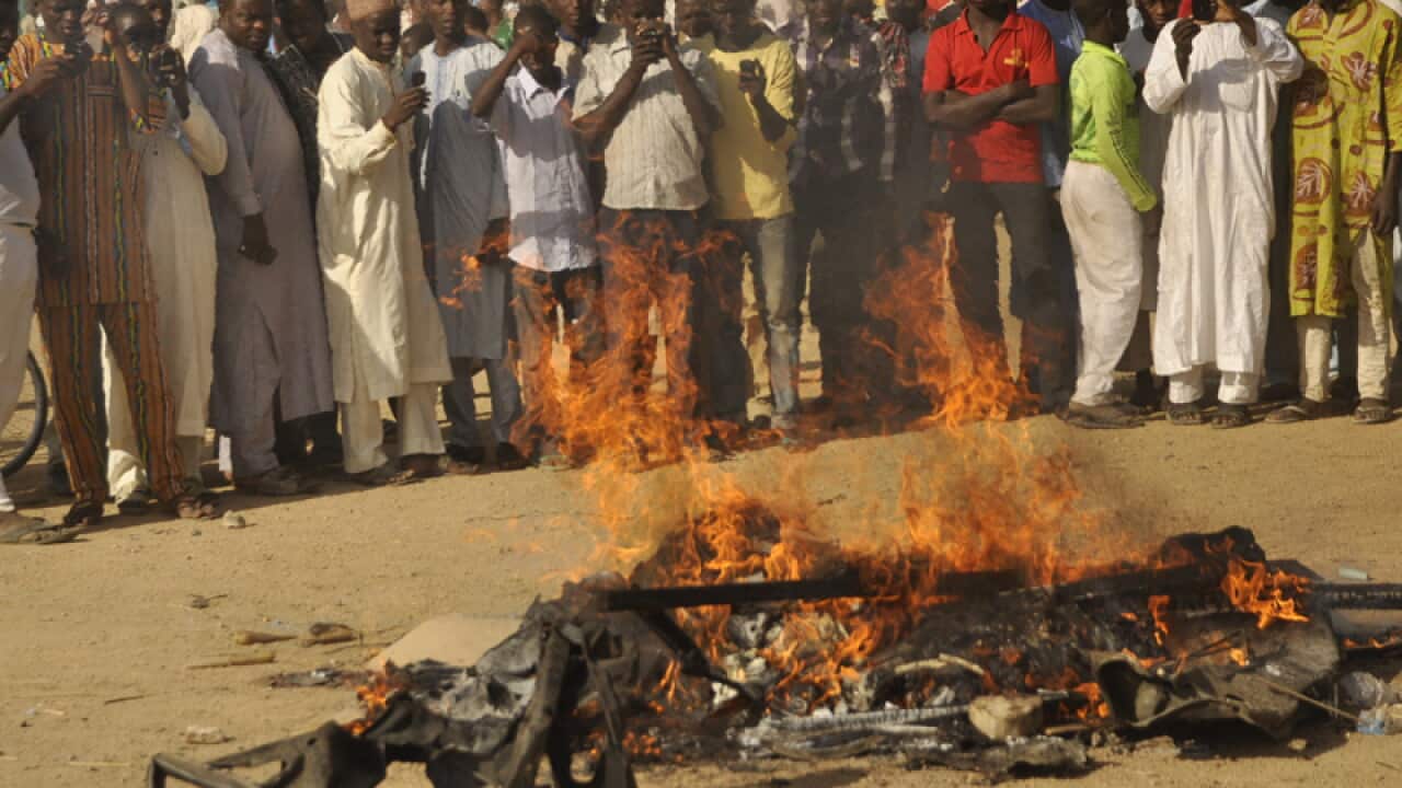 People gather at the site of a bomb explosion in Kano, Nigeria.