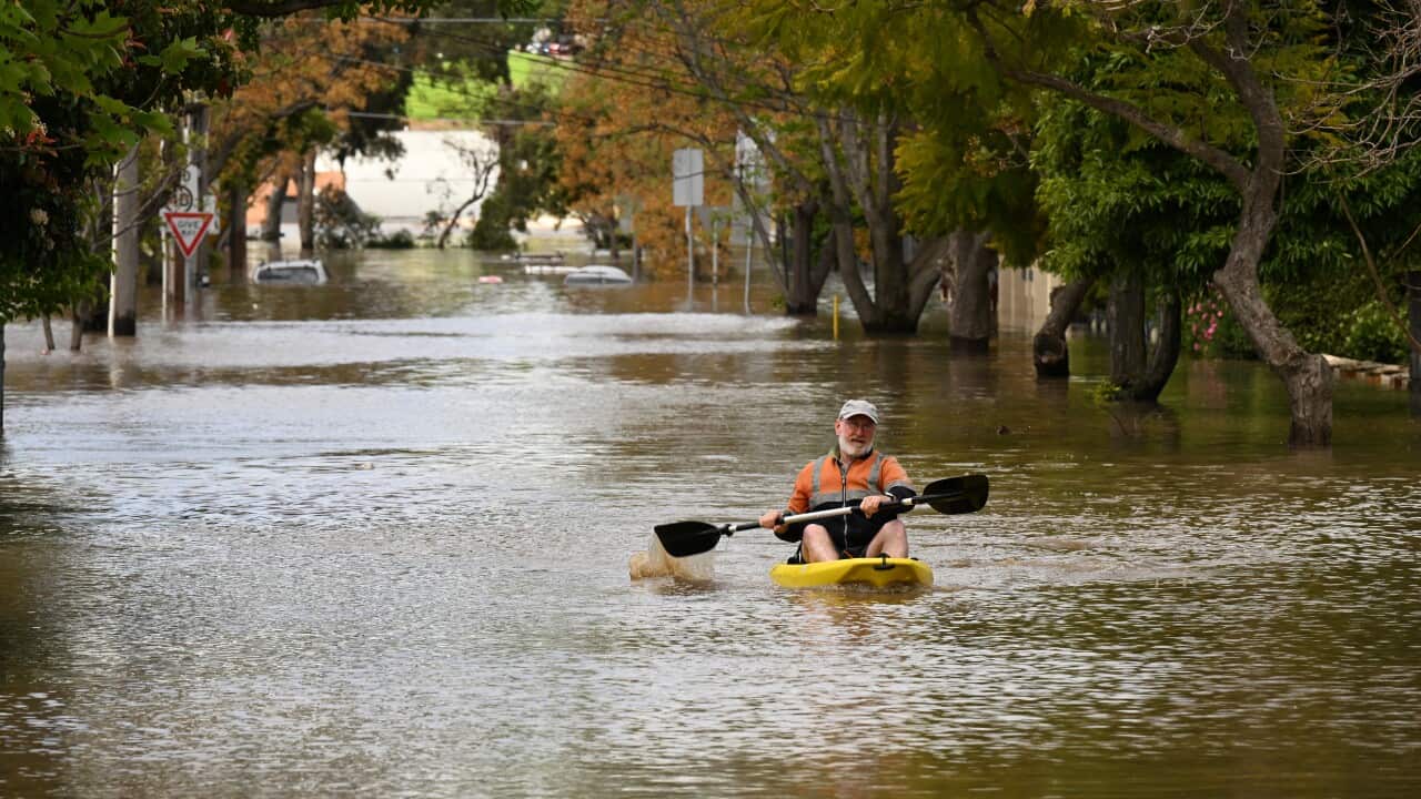 A man canoeing along flood waters.