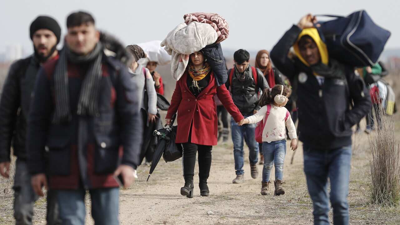 Refugees and migrants walk in a dirty road heading to the Turkish-Greek border and trying to enter Europe, in Edirne, Turkey, 01 March 2020.