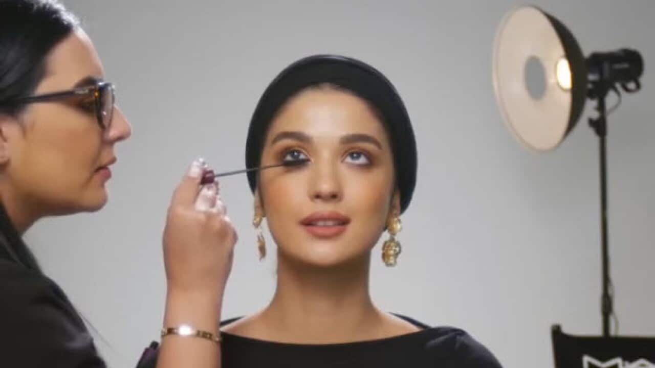 A MAC makeup artist demonstrates a look on a model