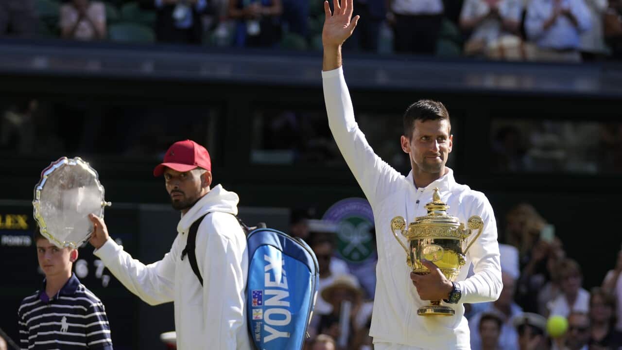 Serbia's Novak Djokovic holds the winners trophy as he celebrates after beating Australia's Nick Kyrgios in London, Sunday, July 10, 2022.