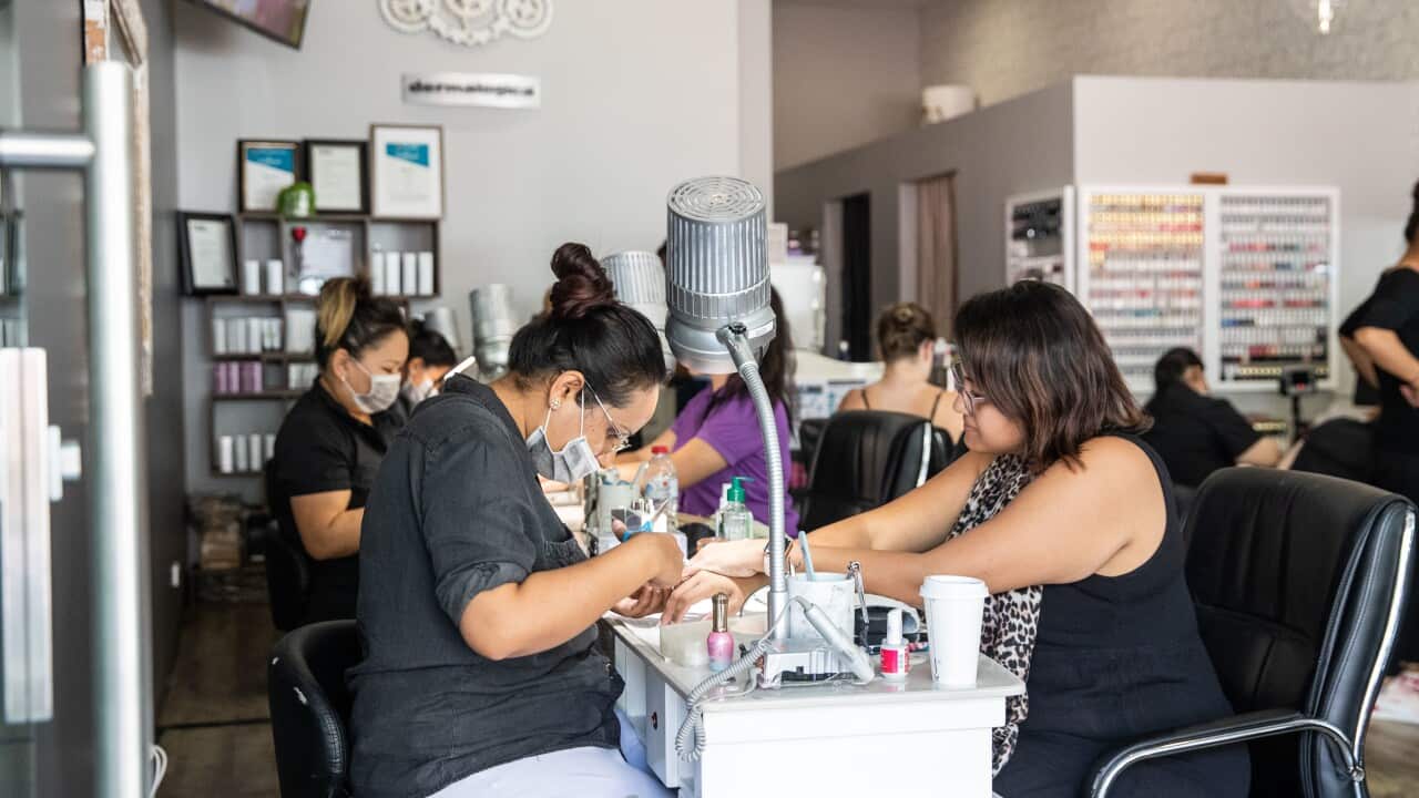Cre8tive Nails owner Rosie Thind with customer in Darwin, Friday, May 15, 2020. The Northern Territory has lifted a range of restrictions but social distancing is still required. (AAP Image/Helen Orr) NO ARCHIVING